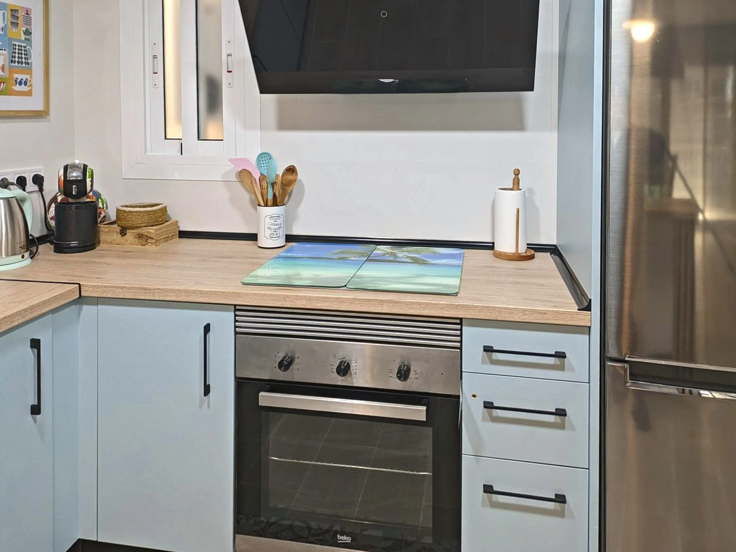 Detalle de la cocina: horno, campana extractora y frigorífico