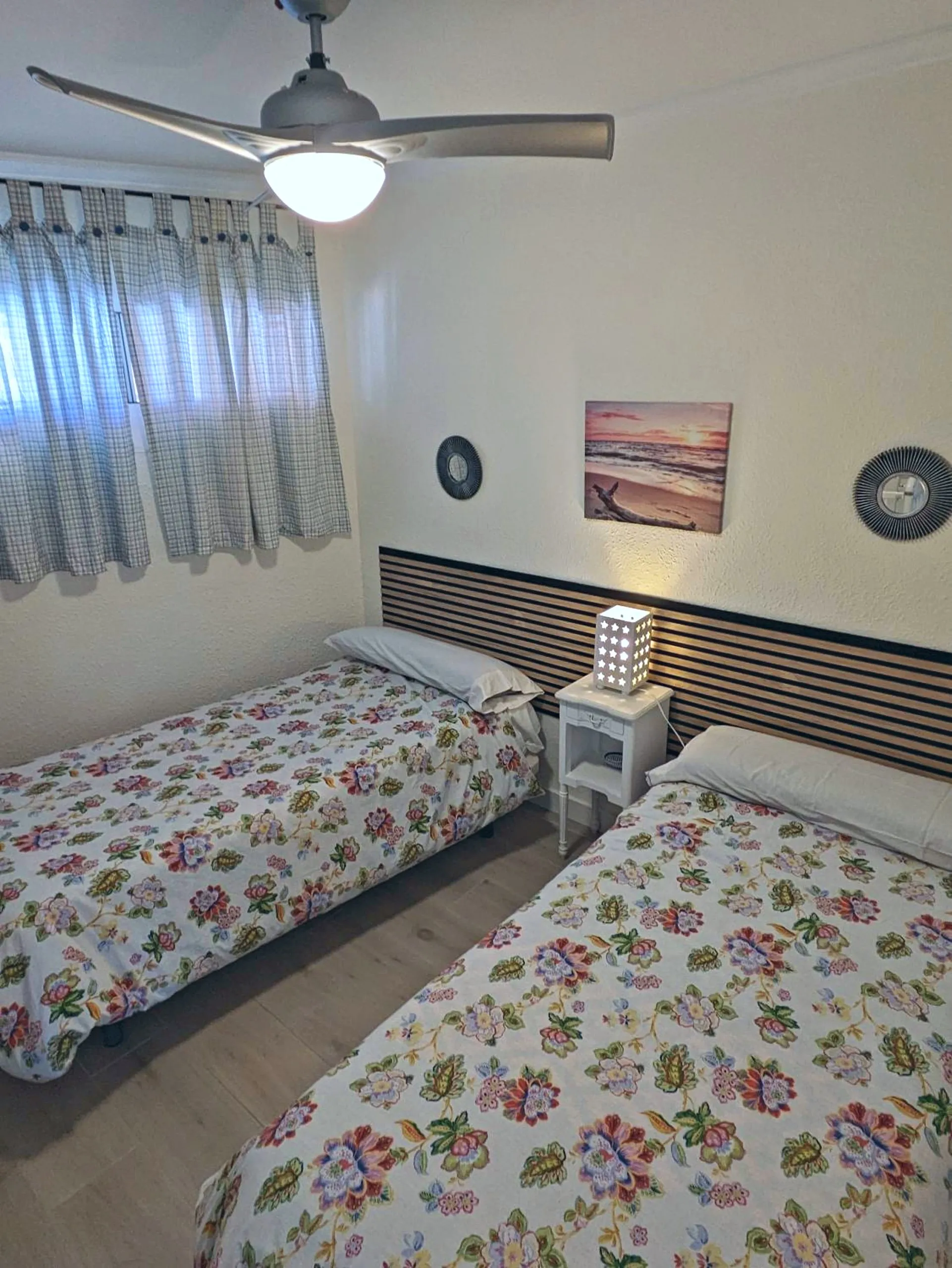 Dormitorio con dos camas individuales y ventilador de techo