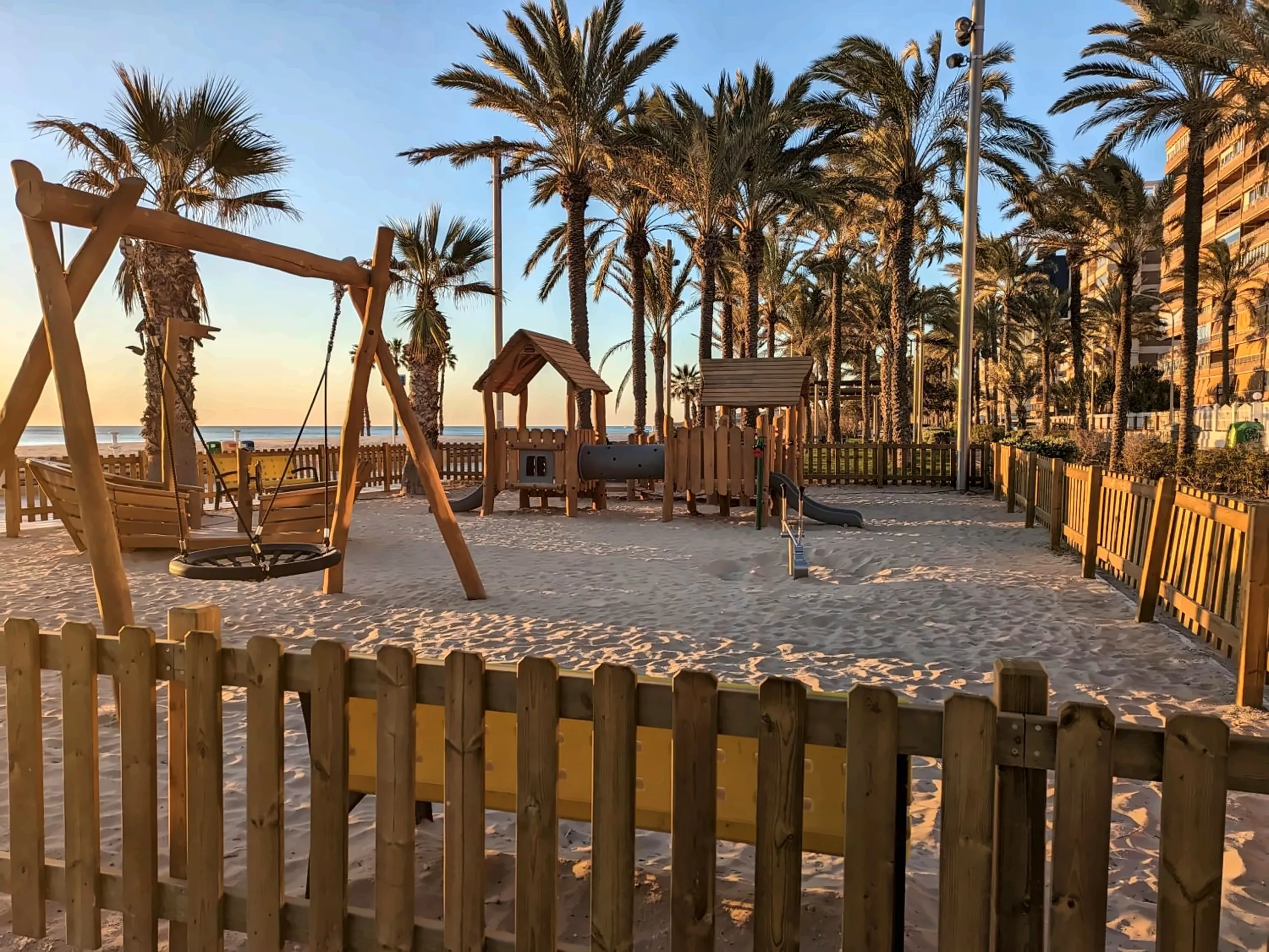 Parque infantil en la playa, entre palmeras